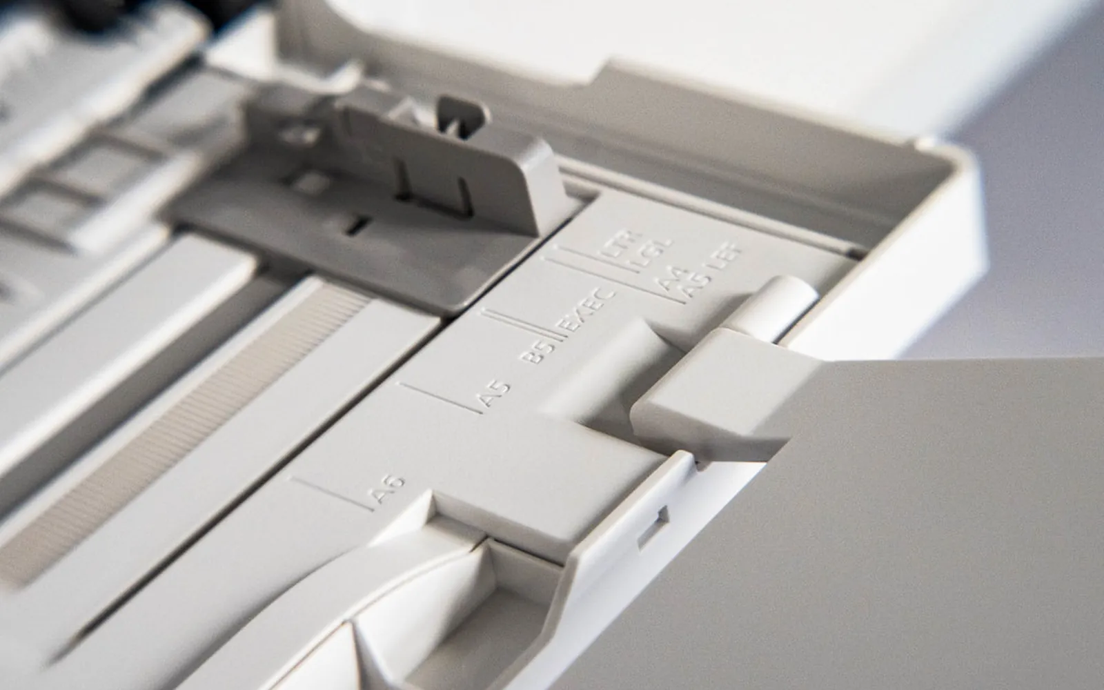 Printer paper tray with adjustable paper size guides